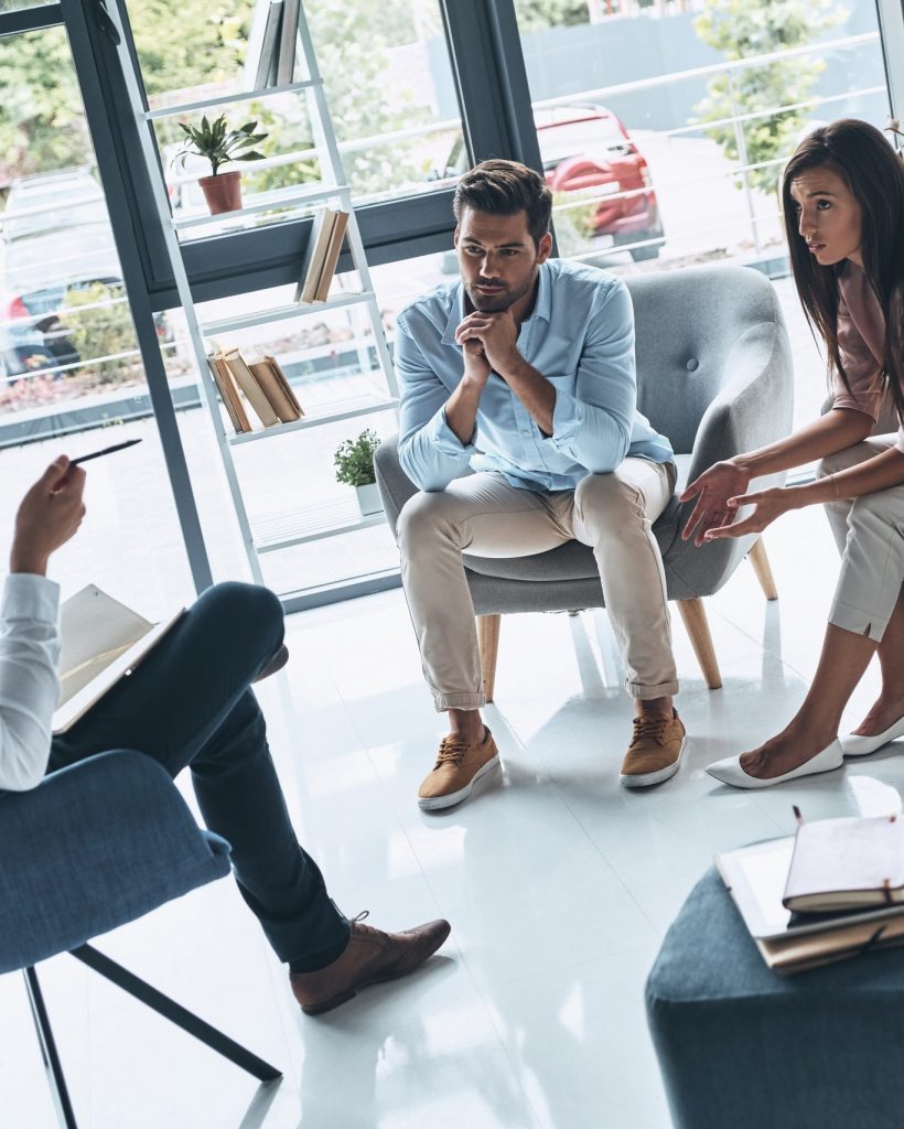 Trust your therapist. Young married couple talking while sitting on the therapy session with psychologist